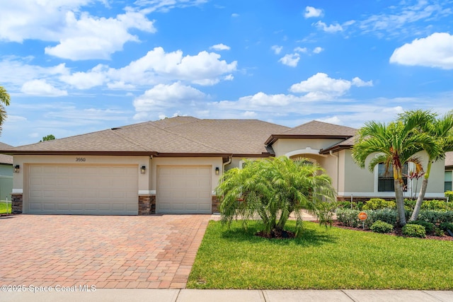 3550 Salt Marsh Cir, West Melbourne, FL 32904 - view of front of house with stucco siding, an attached garage, decorative driveway, stone siding, and a front yard