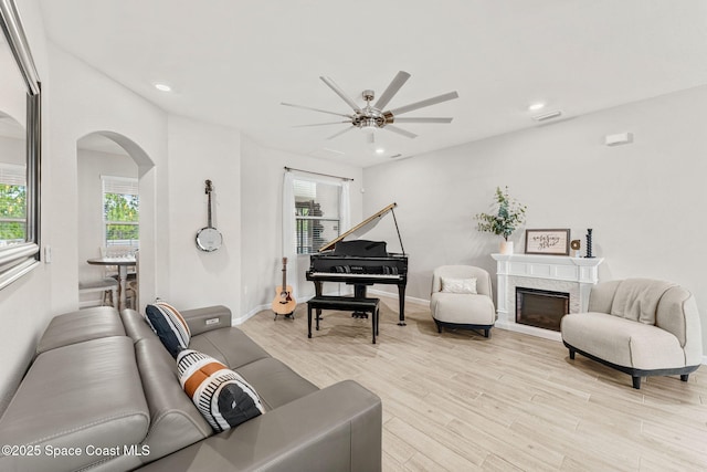 3550 Salt Marsh Cir, West Melbourne, FL 32904 - living room with arched walkways, a ceiling fan, light wood-style flooring, recessed lighting, and a fireplace