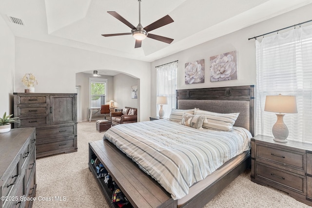 3550 Salt Marsh Cir, West Melbourne, FL 32904 - bedroom featuring a tray ceiling, arched walkways, light colored carpet, and a ceiling fan
