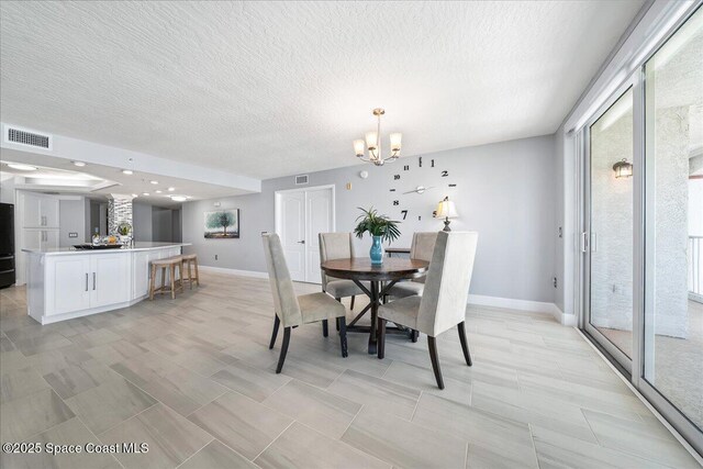 8954 Puerto Del Rio Dr Unit 1503, Cape Canaveral, FL 32920 - dining area with a textured ceiling and a chandelier