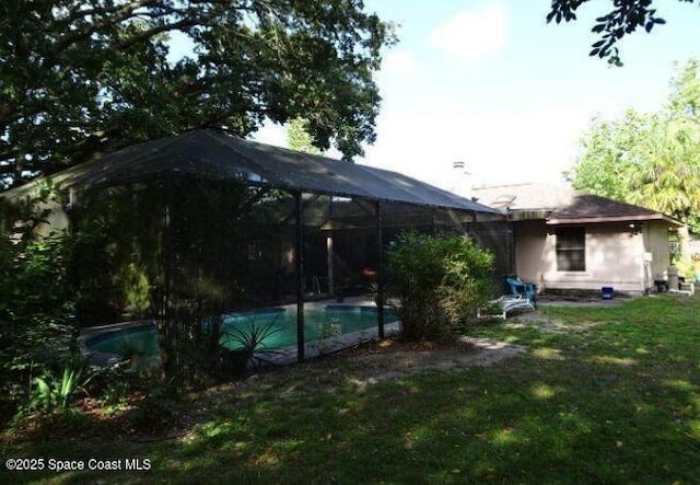 698 Awin Ct SE, Palm Bay, FL 32909 - rear view of house with an outdoor pool, glass enclosure, and a yard