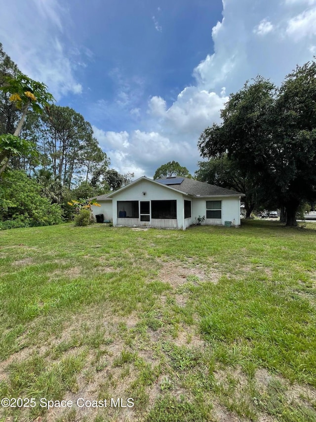 561 Plumbago Rd NW, Palm Bay, FL 32907 - back of property with solar panels and a yard