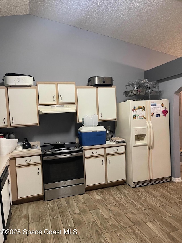 561 Plumbago Rd NW, Palm Bay, FL 32907 - kitchen with stainless steel range with electric stovetop, white fridge with ice dispenser, light wood-style flooring, vaulted ceiling, and light countertops