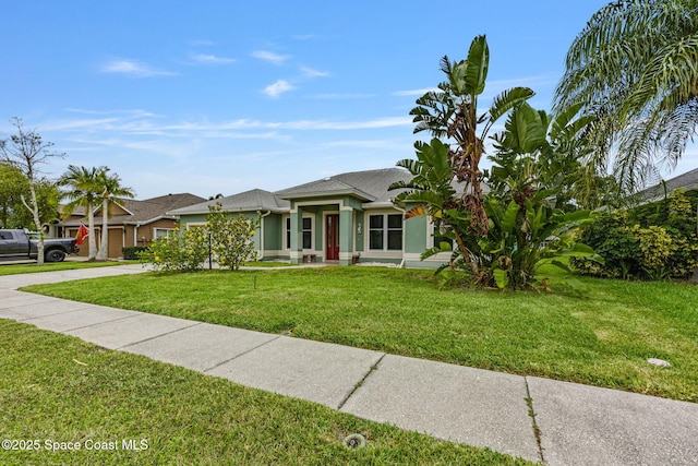 2542 Woodfield Cir, Melbourne, FL 32904 - view of front facade featuring a front yard, driveway, and stucco siding
