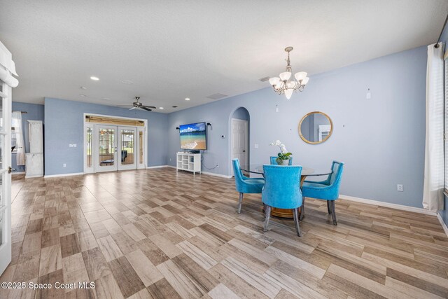 2542 Woodfield Cir, Melbourne, FL 32904 - dining room featuring arched walkways, a ceiling fan, a chandelier, light wood-style floors, and recessed lighting