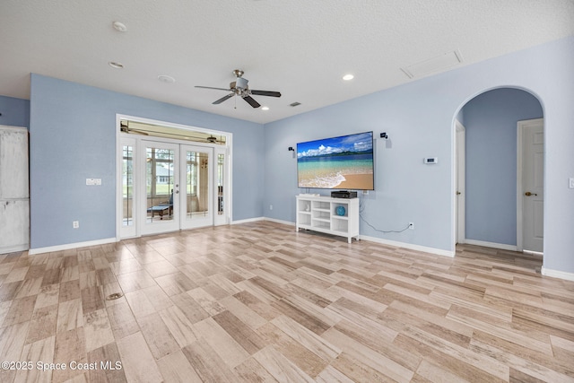 2542 Woodfield Cir, Melbourne, FL 32904 - unfurnished living room featuring arched walkways, french doors, a ceiling fan, recessed lighting, and light wood-type flooring