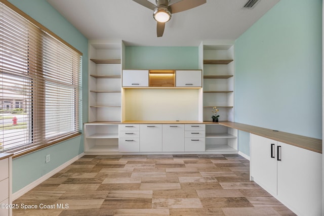 2542 Woodfield Cir, Melbourne, FL 32904 - unfurnished office with built in desk, a ceiling fan, light wood-style flooring, and built in shelves