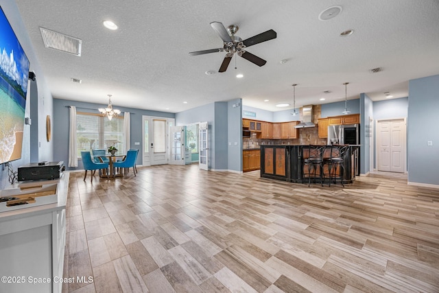 2542 Woodfield Cir, Melbourne, FL 32904 - living room featuring a textured ceiling, recessed lighting, a ceiling fan, a chandelier, and light wood finished floors
