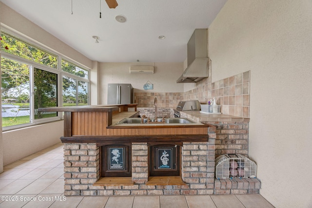 2542 Woodfield Cir, Melbourne, FL 32904 - kitchen with wall chimney exhaust hood, a wall mounted air conditioner, decorative backsplash, freestanding refrigerator, and tile patterned floors