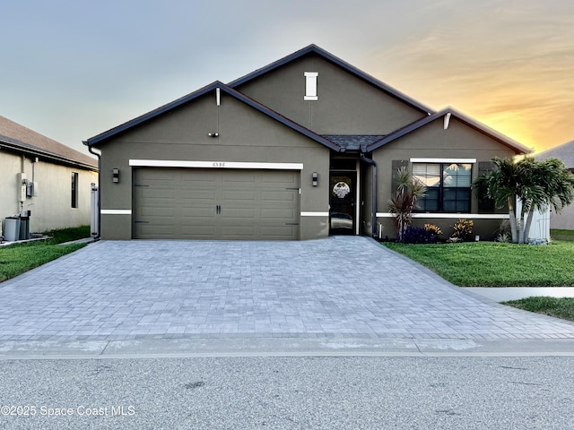 6586 Split Rail Ln, Cocoa, FL 32927 - view of front of home featuring decorative driveway, a garage, stucco siding, and a front yard