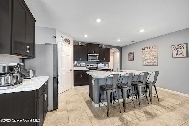 6586 Split Rail Ln, Cocoa, FL 32927 - kitchen featuring appliances with stainless steel finishes, arched walkways, a breakfast bar area, light countertops, and recessed lighting