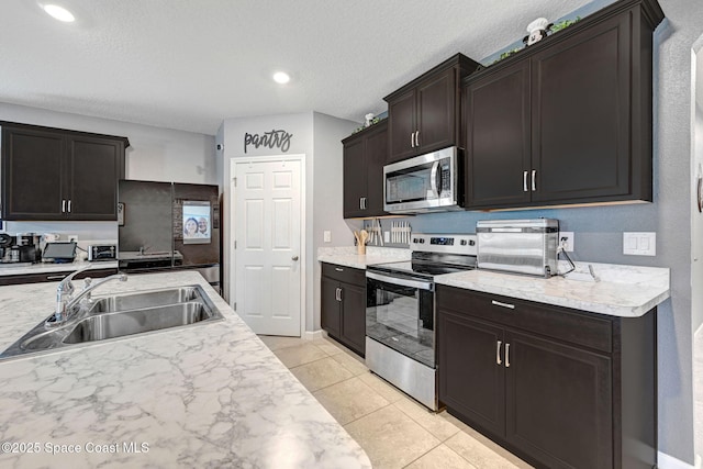 6586 Split Rail Ln, Cocoa, FL 32927 - kitchen with appliances with stainless steel finishes, light countertops, light tile patterned flooring, a textured ceiling, and recessed lighting