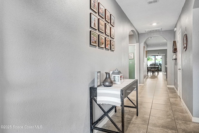6586 Split Rail Ln, Cocoa, FL 32927 - corridor featuring arched walkways, tile patterned floors, and a textured wall