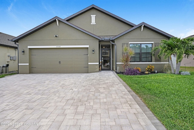 6586 Split Rail Ln, Cocoa, FL 32927 - view of front of property featuring stucco siding, decorative driveway, a front lawn, and an attached garage