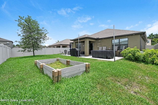 6586 Split Rail Ln, Cocoa, FL 32927 - rear view of house featuring a fenced backyard, stucco siding, a vegetable garden, and a patio