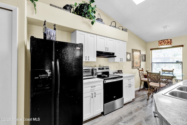 5505 95th St, Sebastian, FL 32958 - kitchen with black fridge, stainless steel electric range, exhaust hood, vaulted ceiling, and light wood-style floors