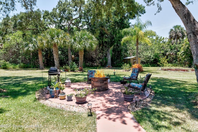 5505 95th St, Sebastian, FL 32958 - view of grassy yard featuring an outdoor fire pit, a patio, and a shed