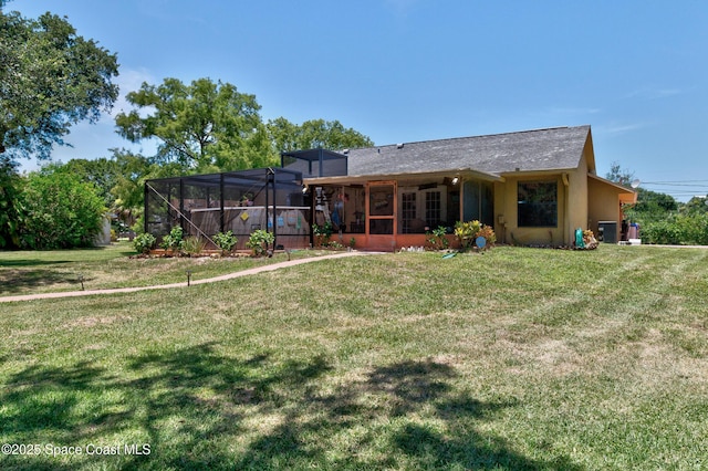 5505 95th St, Sebastian, FL 32958 - rear view of house featuring a lawn, a lanai, and stucco siding