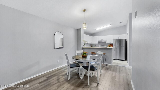 1880 Long Iron Dr Unit 1322, Rockledge, FL 32955 - dining space featuring light wood finished floors and vaulted ceiling