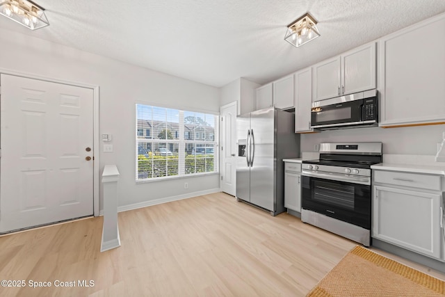 1311 Hampton Park Ln, Melbourne, FL 32940 - kitchen with appliances with stainless steel finishes, light wood-style flooring, and light countertops