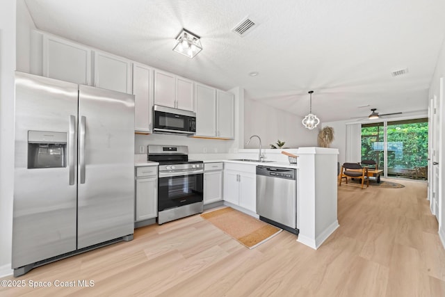 1311 Hampton Park Ln, Melbourne, FL 32940 - kitchen with appliances with stainless steel finishes, a peninsula, light wood-type flooring, light countertops, and a ceiling fan