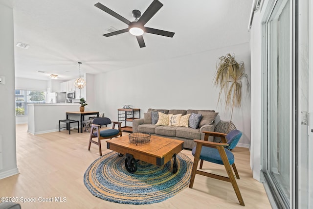 1311 Hampton Park Ln, Melbourne, FL 32940 - living room with light wood finished floors, a ceiling fan, and a chandelier