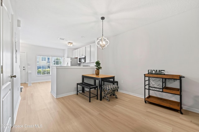 1311 Hampton Park Ln, Melbourne, FL 32940 - dining room featuring light wood finished floors and a chandelier