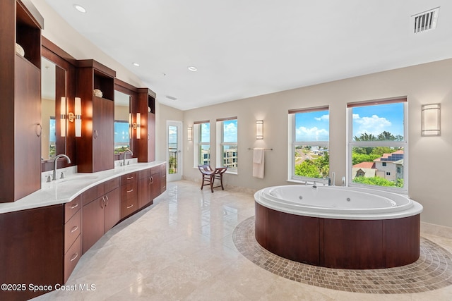 2375 S Atlantic Ave Unit 601, Cocoa Beach, FL 32931 - bathroom with double vanity, a tub with jets, lofted ceiling, and recessed lighting