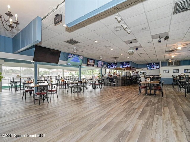 57 Woodland Dr Unit 201, Vero Beach, FL 32962 - dining space featuring a drop ceiling, wood finished floors, a chandelier, and a ceiling fan