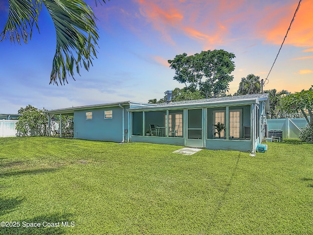 432 N Neptune Dr, Satellite Beach, FL 32937 - back of house at dusk with a sunroom and stucco siding