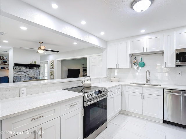 432 N Neptune Dr, Satellite Beach, FL 32937 - kitchen with stainless steel appliances, white cabinets, light stone countertops, light marble finish floors, and recessed lighting