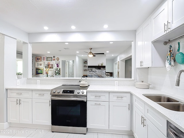 432 N Neptune Dr, Satellite Beach, FL 32937 - kitchen featuring appliances with stainless steel finishes, white cabinetry, a ceiling fan, light stone counters, and a peninsula