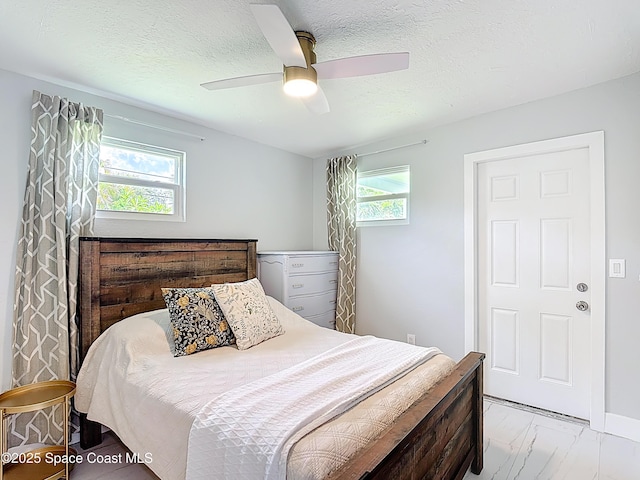 432 N Neptune Dr, Satellite Beach, FL 32937 - bedroom with multiple windows, a ceiling fan, light marble finish floors, and a textured ceiling