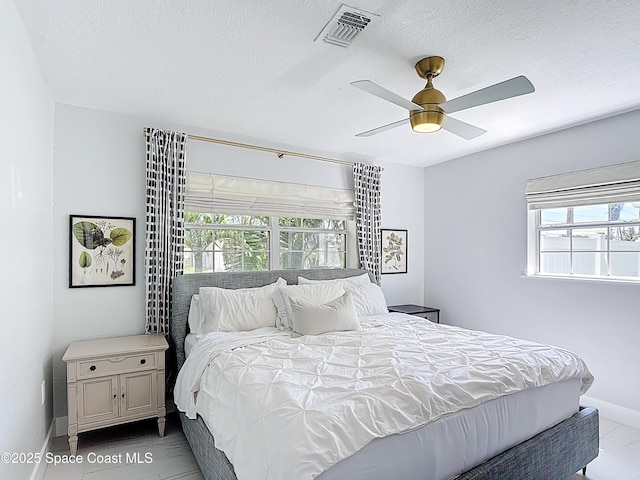 432 N Neptune Dr, Satellite Beach, FL 32937 - bedroom featuring multiple windows, a textured ceiling, and a ceiling fan