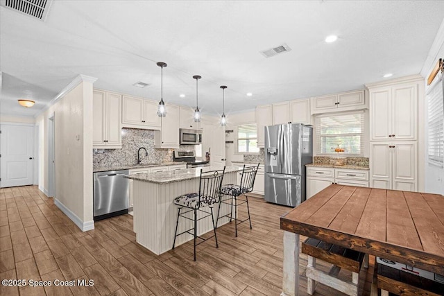 13 Lee St, Cocoa, FL 32926 - kitchen with stainless steel appliances, decorative backsplash, recessed lighting, a kitchen island, and wood finished floors