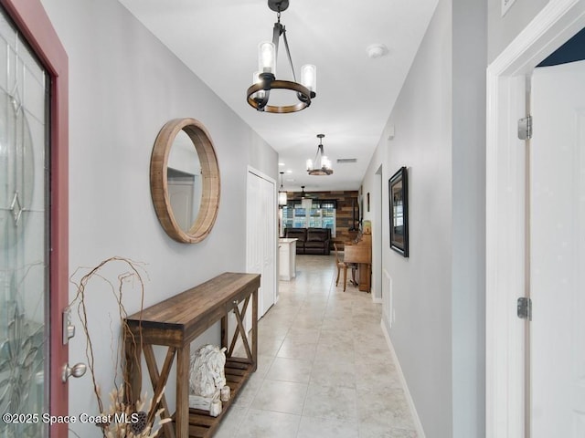 9025 106th Ave, Vero Beach, FL 32967 - hallway with a chandelier and light tile patterned floors
