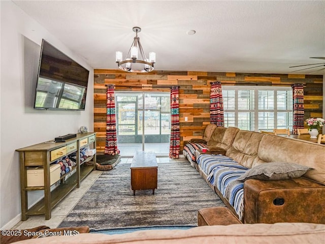 9025 106th Ave, Vero Beach, FL 32967 - living room featuring wood walls, a chandelier, and a ceiling fan
