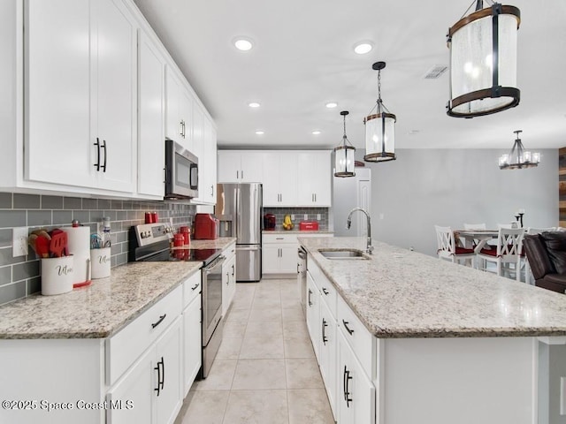 9025 106th Ave, Vero Beach, FL 32967 - kitchen with appliances with stainless steel finishes, backsplash, light tile patterned floors, recessed lighting, and an island with sink