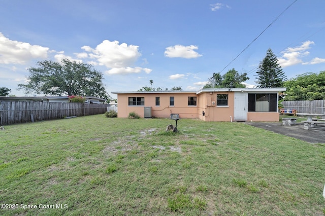 1938 Madison Ave, Melbourne, FL 32935 - back of property featuring a fenced backyard, stucco siding, a patio, and a sunroom