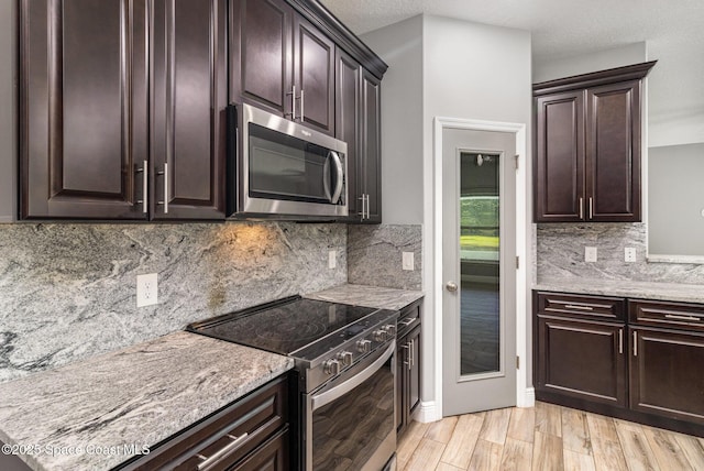 3735 Crista Jean Ave, Grant-Valkaria, FL 32909 - kitchen with appliances with stainless steel finishes, light wood-type flooring, dark brown cabinets, and light stone counters