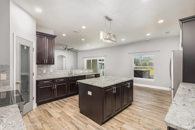 3735 Crista Jean Ave, Grant-Valkaria, FL 32909 - kitchen with appliances with stainless steel finishes, light wood-type flooring, recessed lighting, a kitchen island, and tasteful backsplash