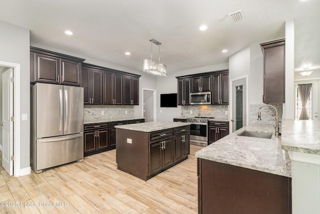 3735 Crista Jean Ave, Grant-Valkaria, FL 32909 - kitchen with stainless steel appliances, backsplash, light stone counters, light wood-type flooring, and recessed lighting