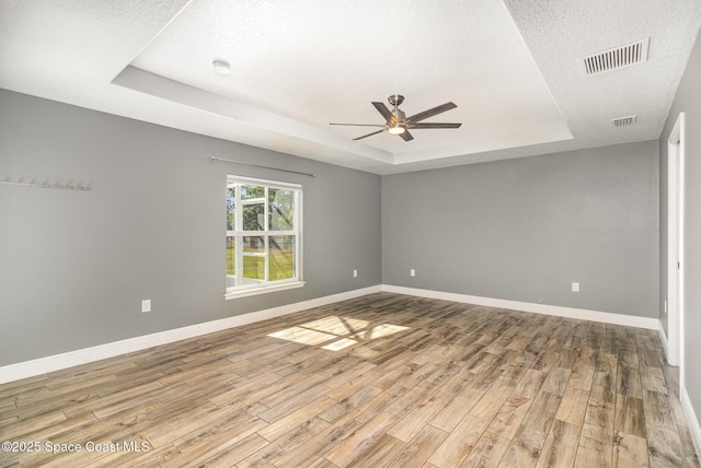 3735 Crista Jean Ave, Grant-Valkaria, FL 32909 - empty room featuring a raised ceiling, ceiling fan, light wood-type flooring, a textured ceiling, and a smoke detector