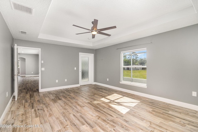 3735 Crista Jean Ave, Grant-Valkaria, FL 32909 - spare room with a tray ceiling, light wood finished floors, and a ceiling fan