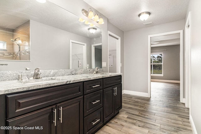 3735 Crista Jean Ave, Grant-Valkaria, FL 32909 - full bathroom with double vanity, wood finished floors, and a textured ceiling