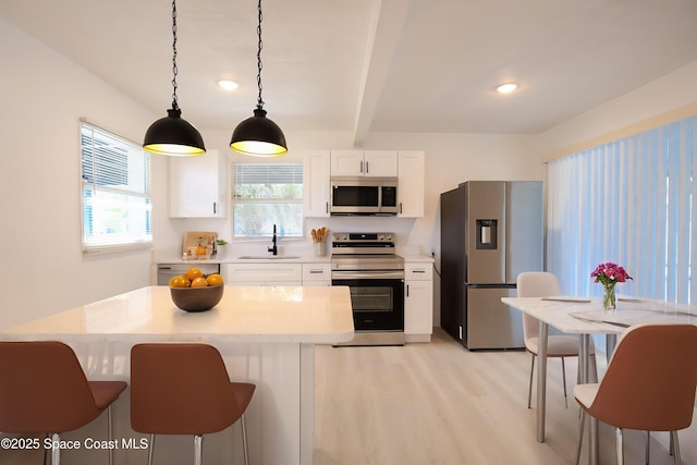 1810 Dixon Blvd, Cocoa, FL 32922 - kitchen with stainless steel appliances, light wood-type flooring, white cabinets, light countertops, and pendant lighting