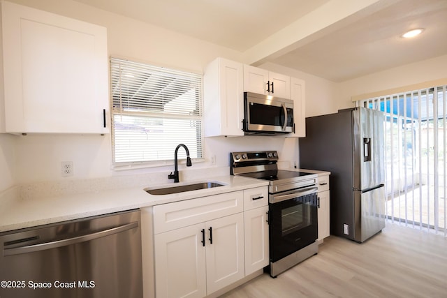 1810 Dixon Blvd, Cocoa, FL 32922 - kitchen featuring stainless steel appliances, light wood-style floors, white cabinetry, light countertops, and beamed ceiling