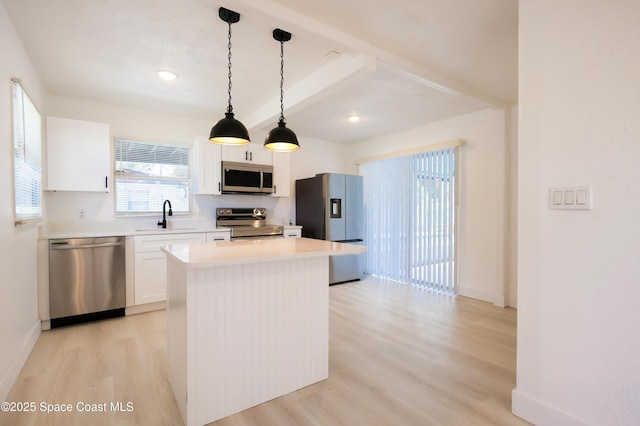 1810 Dixon Blvd, Cocoa, FL 32922 - kitchen featuring stainless steel appliances, light wood-style flooring, beam ceiling, a kitchen island, and white cabinetry