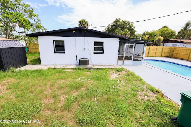 1810 Dixon Blvd, Cocoa, FL 32922 - back of house featuring a fenced backyard, a sunroom, and a shed