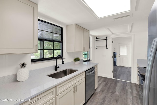 5685 Jamaica Rd, Cocoa, FL 32927 - kitchen featuring stainless steel appliances, wood finished floors, light stone counters, and white cabinetry
